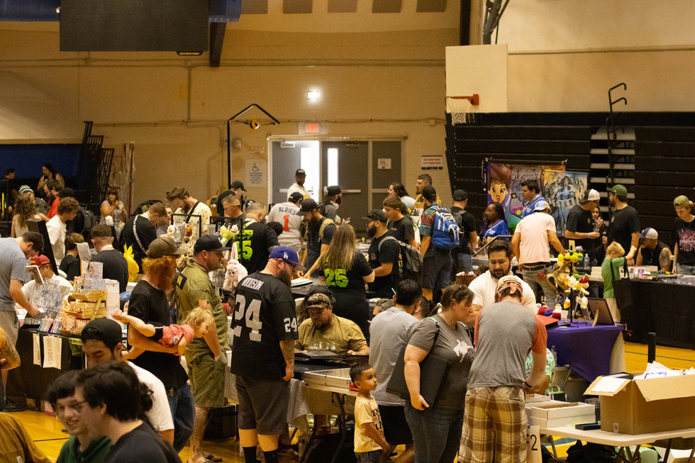 Attendees browsing vendor tables across the PTCC card show floor